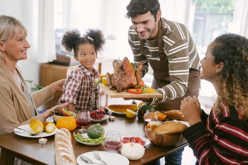 A happy family celebrating Thanksgiving dinner at home, embracing the tradition with joy and togetherness.