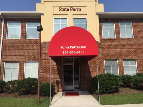 Yellow and brick building with red awning and red State Farm sign