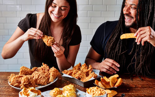 Customers enjoying hand-breaded fried chicken, Cajun tenders, honey biscuits, and sides at Krispy Krunchy Chicken®, a go-to spot for fried chicken near you.