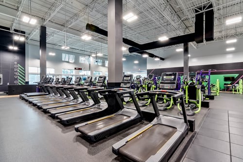 a row of pristine walking machines in a shiny renovated youfit gym