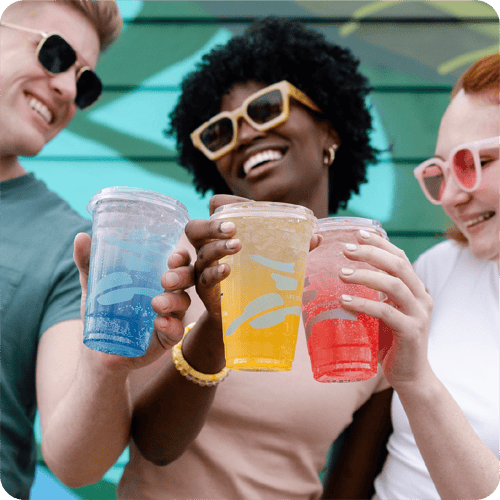Three people smiling and enjoying energy drinks