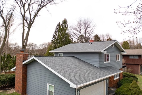 new asphalt shingle roof on blue house