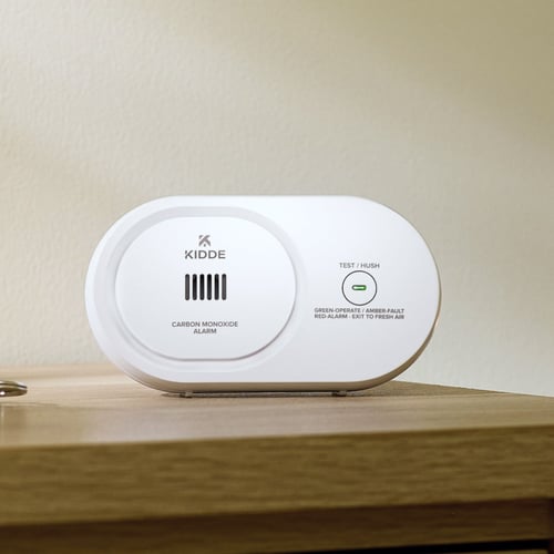 A carbon monoxide detector sits on a table.