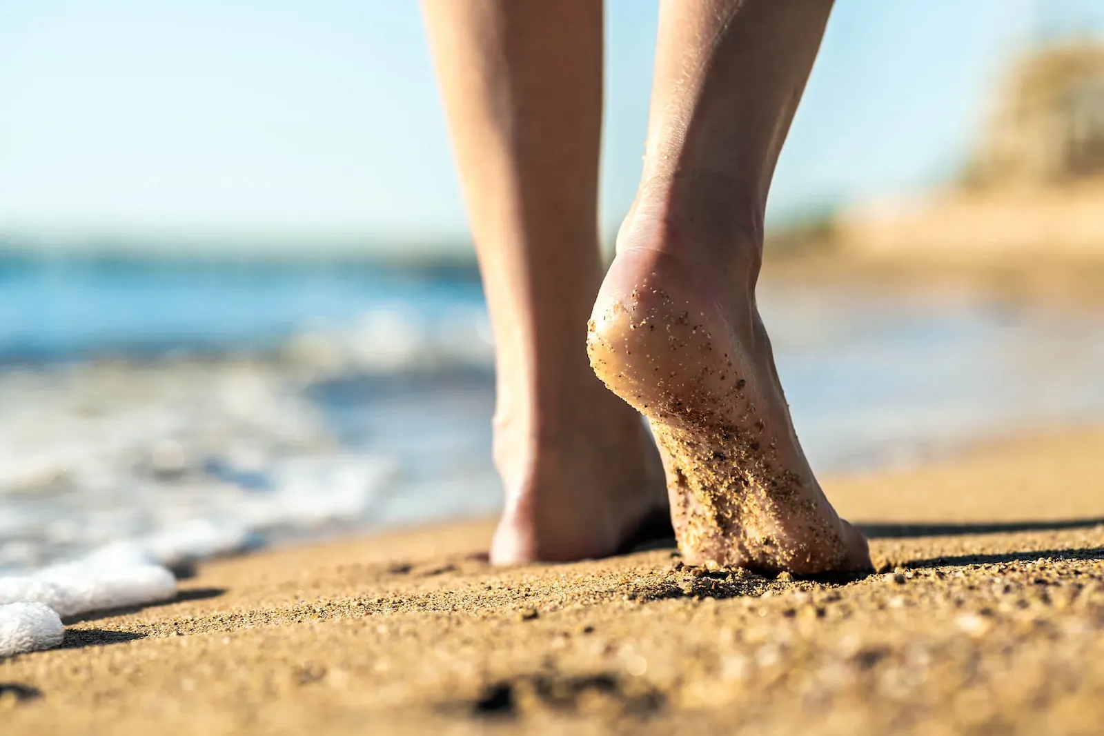 person walking on the beach barefoot