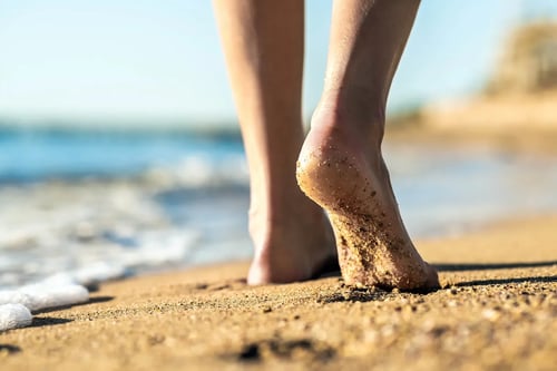 person walking on the beach barefoot