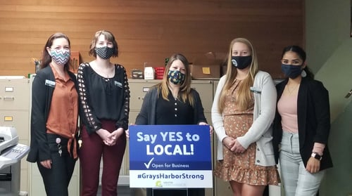 5 Timberland Bank employees pose with a sign reading Say Yes to Local