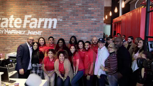 Agent Hielly and team members standing and smiling in office