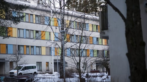 Ulkokuva Kuninkaankallion rakennuksesta. Rakennus on neljäkerroksinen ja ikkunoiden väliset tilat on maalattu eriväreillä. Maassa on lunta.
