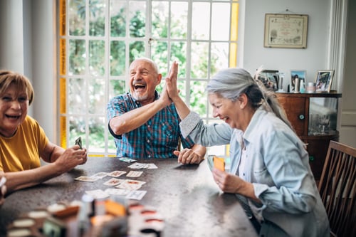 A group of seniors enjoying a friendly game of cards together, sharing laughter and good company.