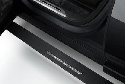 Close-up of a Range Rover door sill with illuminated branding and step detail.