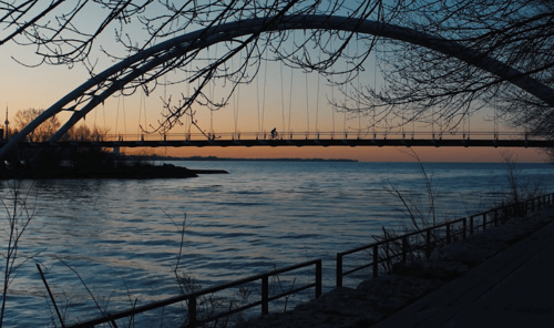 Cyclist crossing Etobicoke bridge at dawn