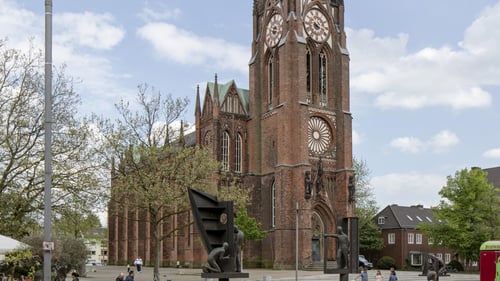 Das Kirchengebäude mit einem hohen und schmuckvoll gestaltetem Kirchturm.