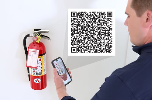 A person scans a QR code on the fire extinguisher