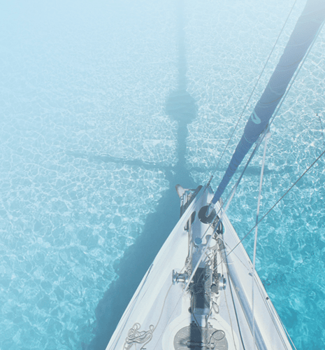 A sailboat in clear blue water.