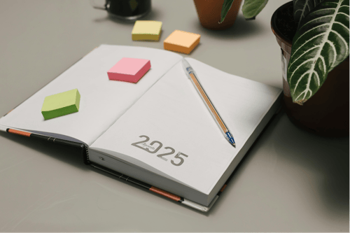 A 2025 planner opened to the first page with a pen and sticky notes resting on top.