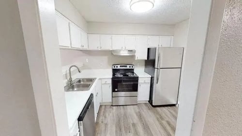Fully equipped kitchen with stainless steel appliances and white cabinets at 2000 Oasis Apartments in Atlanta, GA