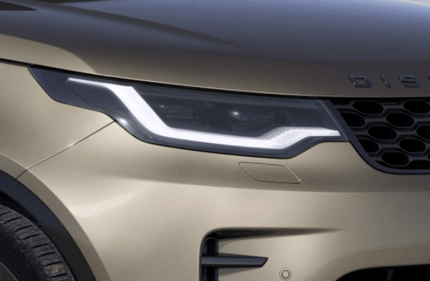 Close-up of a Discovery front headlight with distinctive LED light signature and grille detail