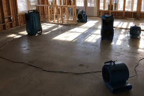 Drying equipment, including air movers and dehumidifiers, is placed in a home after a water damage loss in Conway