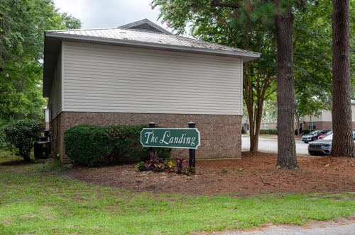 A small building with a sign that says The Landing in front of it.