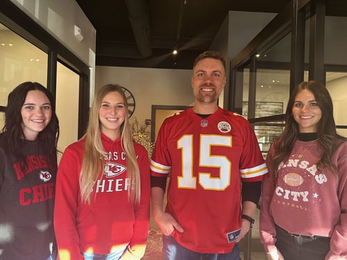 Agent Philip and three team members standing and smiling wearing football attire