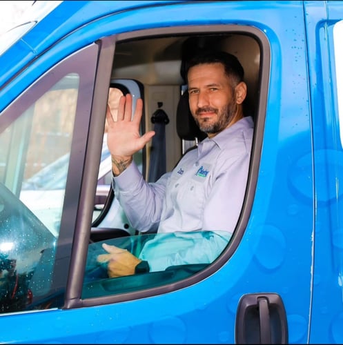 plumber in van waving
