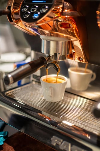 Siebträgermaschine, die frischen Espresso mit Crema in eine Tasse gießt.