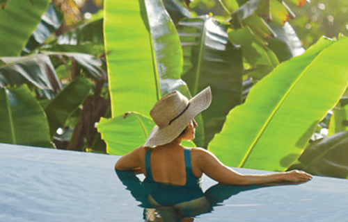 woman sitting in tropical pool