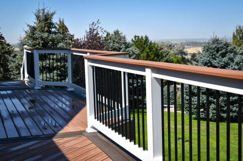 Classic all-white vinyl deck railing installed on a modern gray composite deck by DeckPro LLC in Idaho.