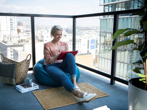 Women on apartment balcony using internet
