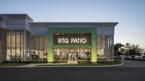 Exterior of RTG Patio store in Daytona Beach, Florida, featuring large glass windows and a prominent illuminated sign.