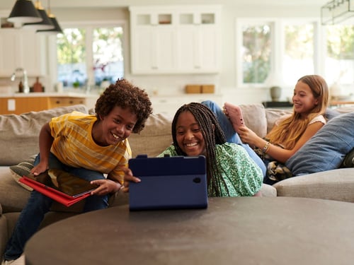 Three kids using fiber internet on their tablets