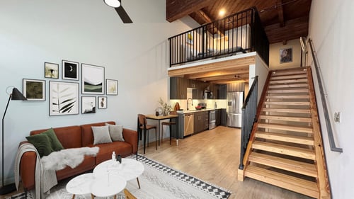 A living room with a couch, a coffee table, and a staircase leading to the upper floor at B Flats Apartments, Bremerton, Washington