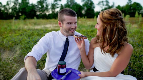 couple eating blueberries in field