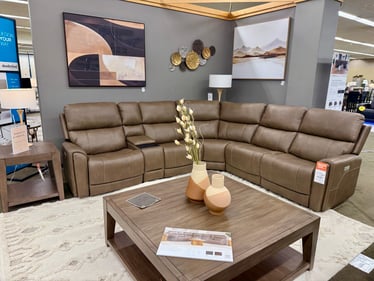 Brown Flexsteel power reclining sectional with storage console and neutral wall art at Slumberland Furniture Burlington. Shop power reclining sectionals and motion furniture in Burlington, Iowa.