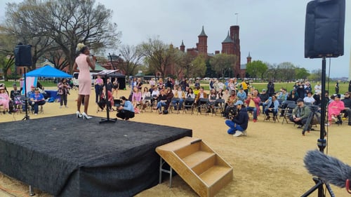 Woman speaking on an outside stage