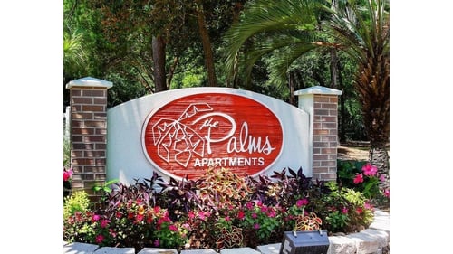 Property entrance signage at The Palms Apartments.
