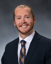 Dr. Grimm smiling in front of a gray background.