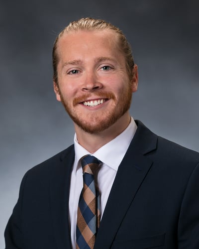 Dr. Grimm smiling in front of a gray background.