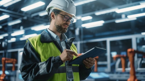 Worker with tablet in manufacturing plant