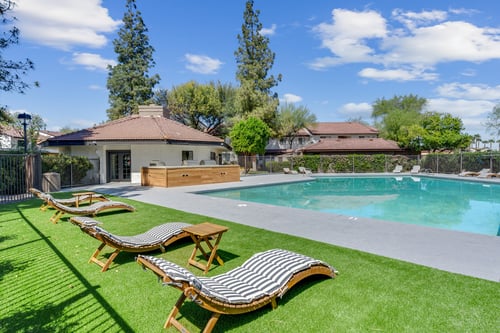 A house with a pool and sun loungers.
