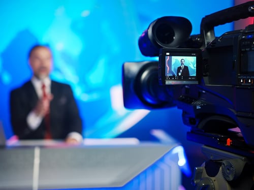 A news anchor in front of a camera