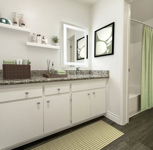 A bathroom with white cabinets and a marble countertop at Ridgeline Apartments in San Bernardino