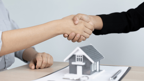 two people shaking hands over a contract