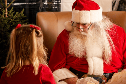 A little girl next to Santa Claus.