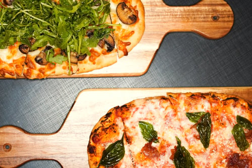 flatbread pizzas on cutting board