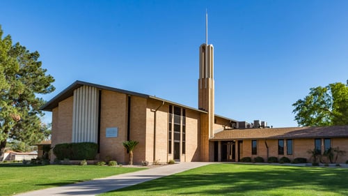 Large brick church building with tall spire