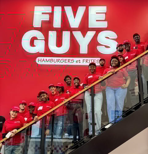 Crew members pose for a photograph on the stairs inside the new Five Guys restaurant at 1232 Peel Street in Montreal, Quebec, Canada.