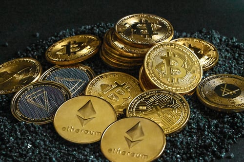 A pile of gold coins representing Bitcoin and Ethereum.