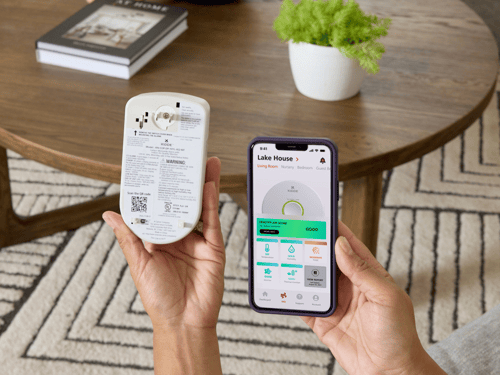A person sets up their Indoor Air Quality Monitor with the Kidde App.
