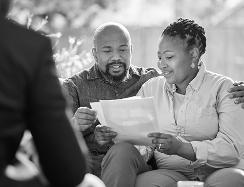 A couple meeting with an advisor and reading documents.